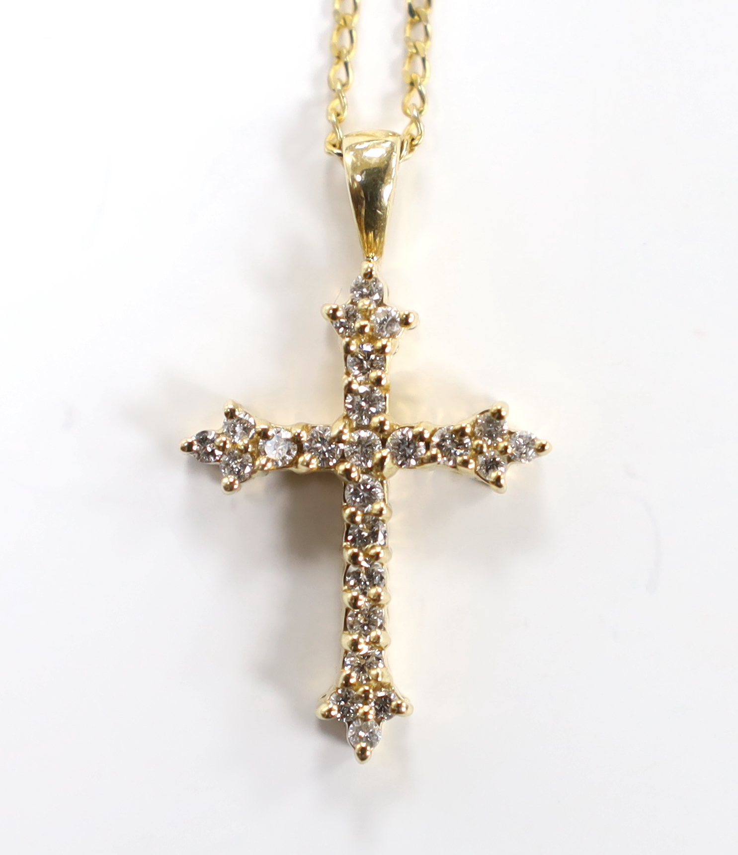A modern 9ct gold and diamond chip set cross pendant, overall 30mm, on a 9ct gold chain, 40cm, gross weight 4.3 grams.
